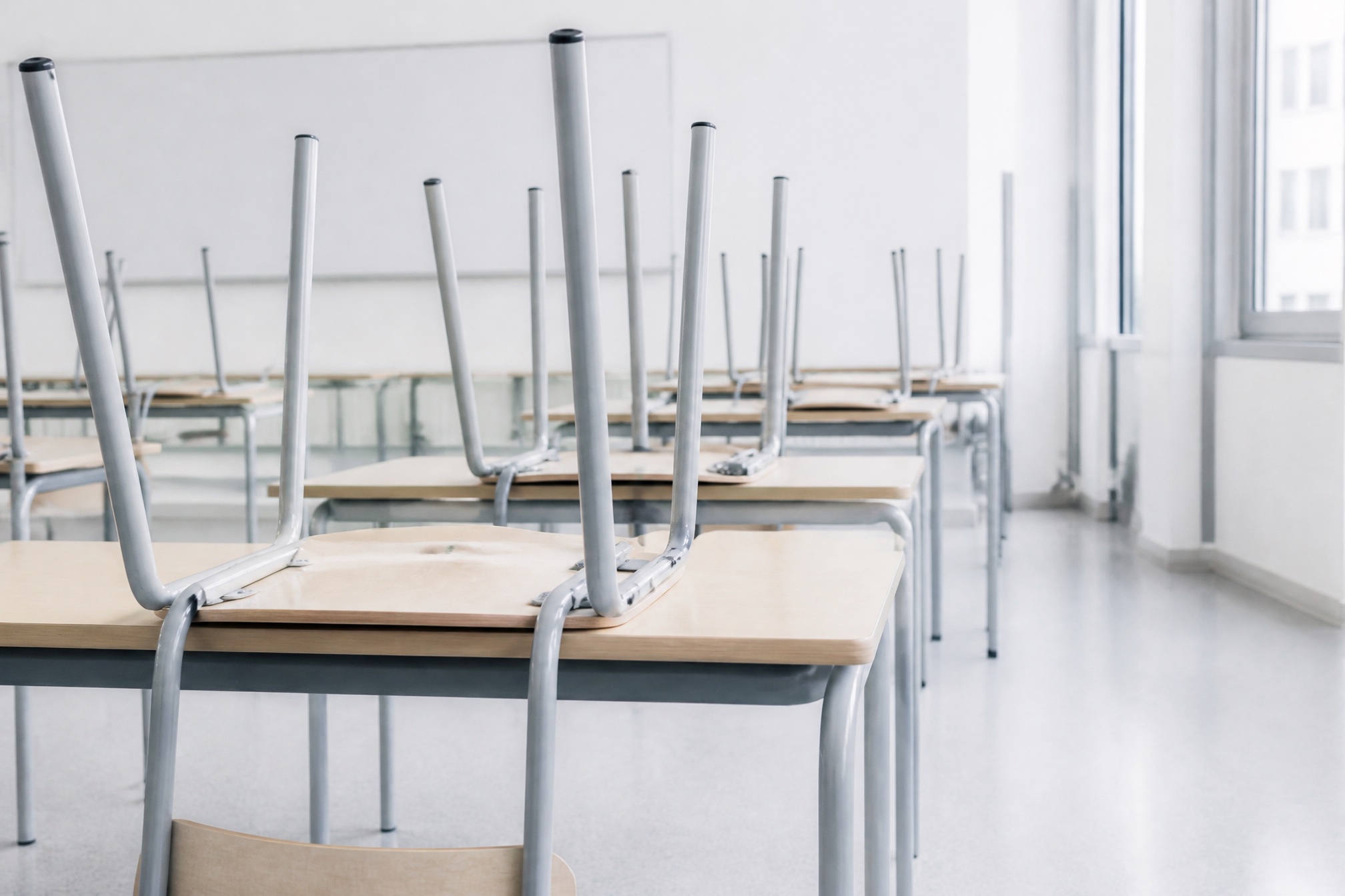Klassenraum mit hochgestellten Stühlen auf den Tischen, der Boden frei und frisch gewischt